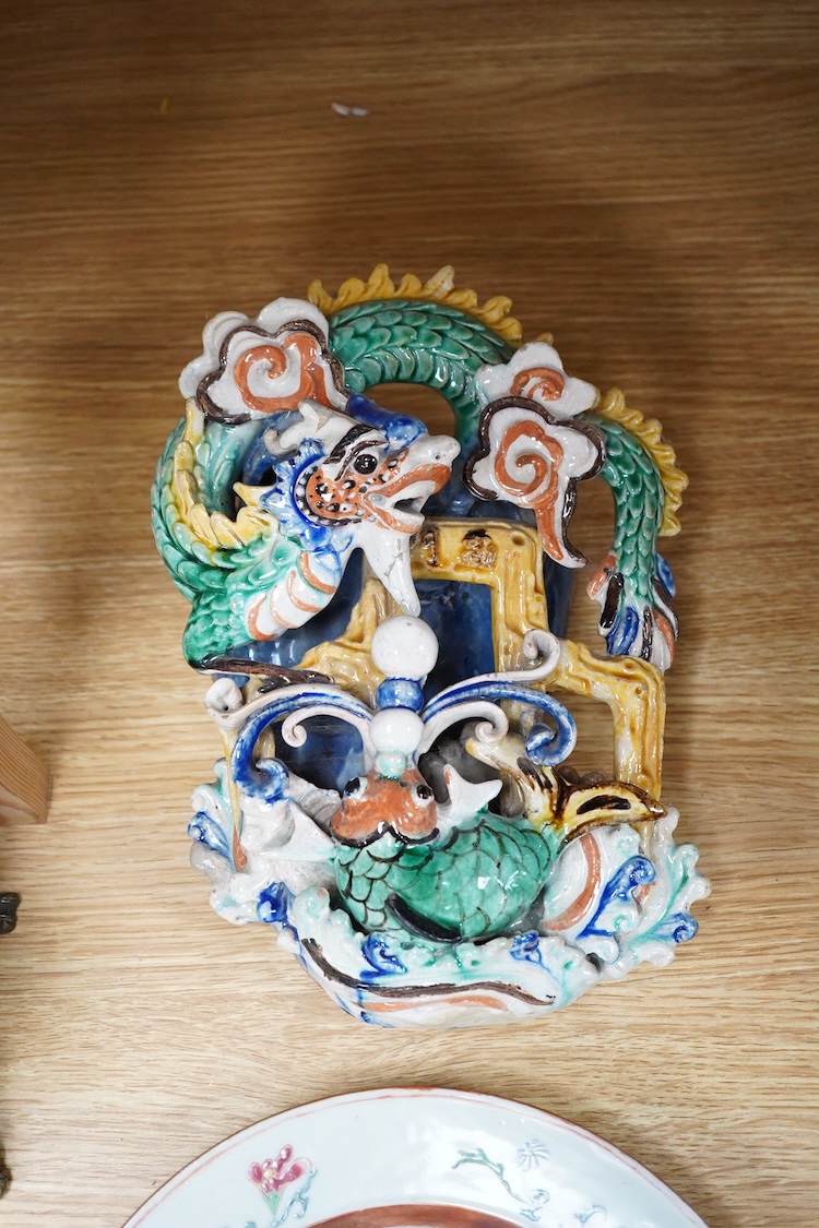 An 18th century Chinese porcelain plate enamelled with flowers and a Chinese Sancai type wall pocket, largest 25cm high